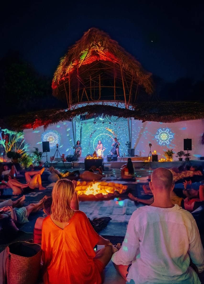 A couple in deep sound immersion before the AUM dome stage at night